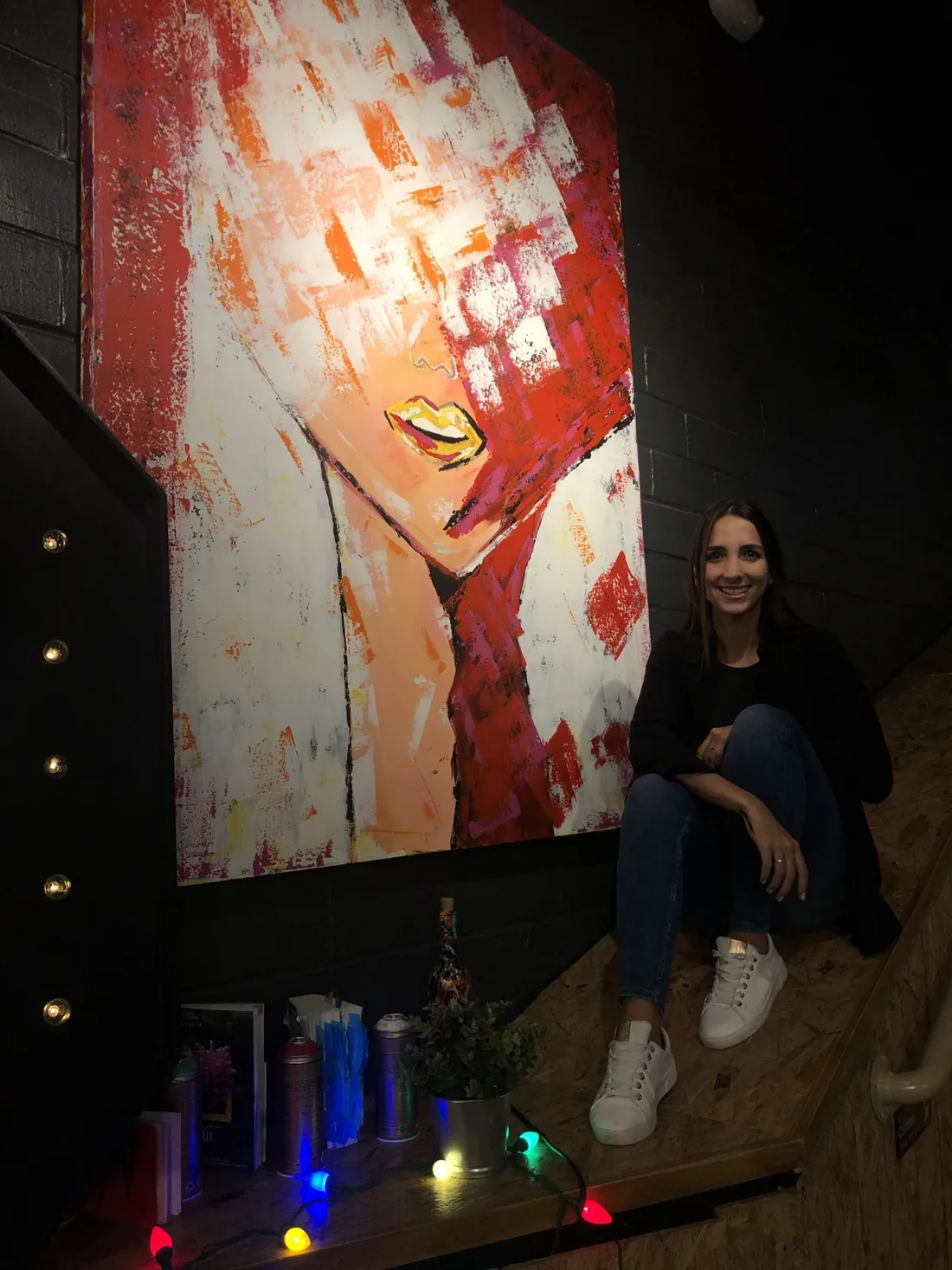 Tamy sentada junto a una obra de Caras Vemos